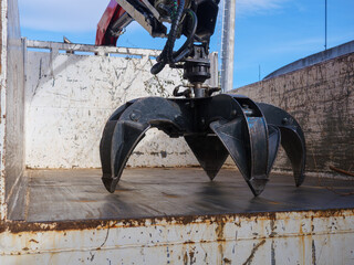 Powerful multi-jaw grapple for industrial material handling on loader or crane. Heavy equipment for forestry, scrap yards, recycling. Robust steel grab for bulk transport, sorting logs, metal, waste.