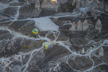 Balloons fly over Cappadocia at sunrise. 