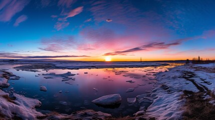 Stunning arctic sunset over icy water and snow covered shore