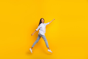 Full length photo of millennial lady jump up profile imitate walking wear shirt jeans isolated yellow color background