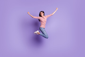 Full length size view of nice attractive lovely glad cheerful girl jumping having fun rising hands up isolated on violet color background