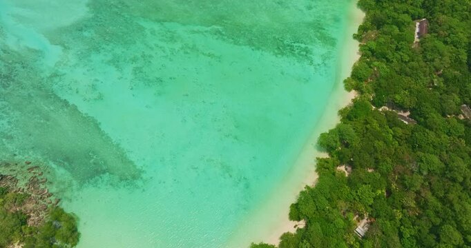 Aerial view of Mai Ngam beach in Surin Islands coastline with its lush green forests, white sand beach, coral reefs and deep blue waters filled with coral and a variety of fish. camping place