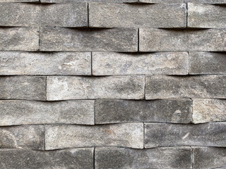 The texture of the rectangular andesite stone wall arranged neatly displays a variety of natural shapes and nuances, giving a strong aesthetic impression.