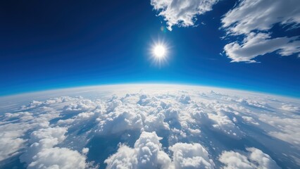 Naklejka premium View of Earth and bright sun shining through scattered cumulus clouds, clear blue sky