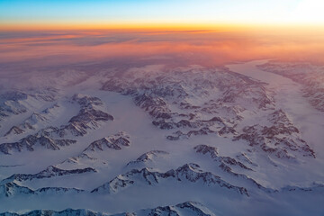 Aerial view of snow mountain and frozen river in colorful morning sunlight in Alaska