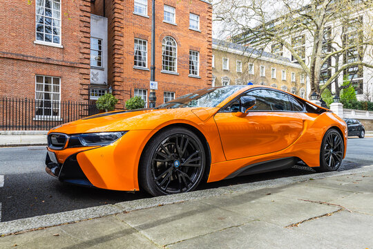 Vibrant Orange BMW i8 Sports Car Parked on Stylish London Street. London, UK, 6 April 2024