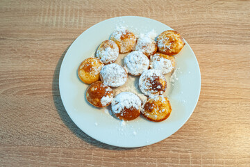 Plate with traditional Dutch batter cakes known as poffertjes, sprinkled with powdered sugar