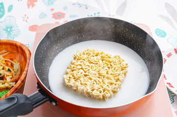 鍋で牛乳と水でインスタントラーメンを茹でる