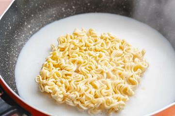 鍋で牛乳と水でインスタントラーメンを茹でる