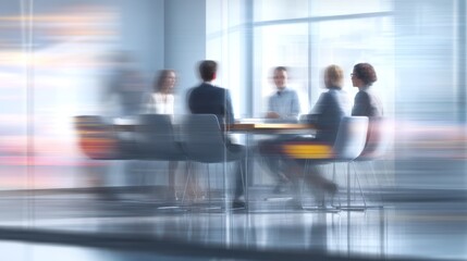 Business people sit at a table in an office setting motion blur.