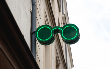 Un éclairage au néon en forme de lunettes, pour signaler la présence d'un opticien.