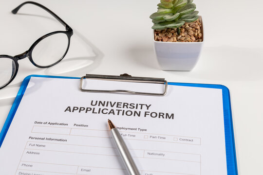 University Application Form in Clipboard on White Desk – Education & Admission Concept