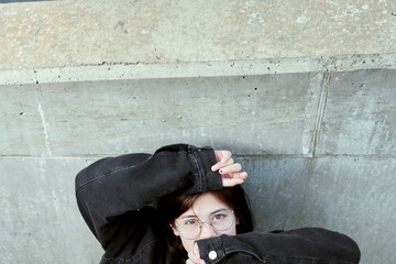 Creative Overhead Portrait of Young Woman Peeking Through Sleeved Arms
