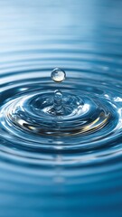 Close-Up of a Water Droplet Creating Ripples on a Tranquil Blue Surface