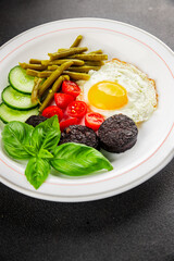 English breakfast fried egg, black pudding, vegetables, beans fresh delicious gourmet food...