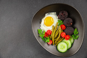 English breakfast fried egg, black pudding, vegetables, beans fresh delicious gourmet food background on the table rustic food top view copy space