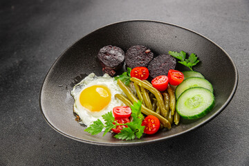 English breakfast fried egg, black pudding, vegetables, beans fresh delicious gourmet food background on the table rustic food top view copy space