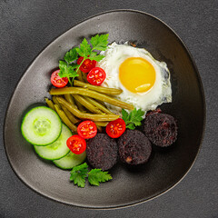 English breakfast fried egg, black pudding, vegetables, beans fresh delicious gourmet food background on the table rustic food top view copy space