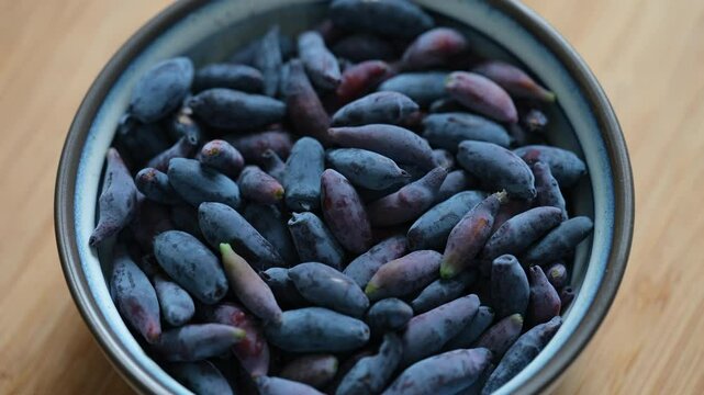 A bowl of freshly harvested honeysuckle berries. Close up.