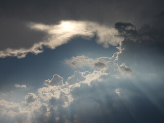 A bright sun breaks through the storm clouds, emitting an array of heavenly sunbeams. Stormy skies above Kent County, Delaware. Cloudscape.