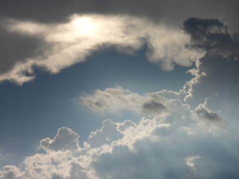 A bright sun breaks through the storm clouds, emitting an array of heavenly sunbeams. Stormy skies above Kent County, Delaware. Cloudscape.