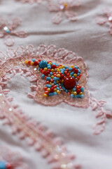 Obraz premium Beautiful embroidery on a pink fabric. Close-up.