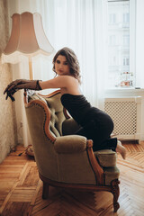 Fashion Model in Black Dress Leaning Elegantly on Chair