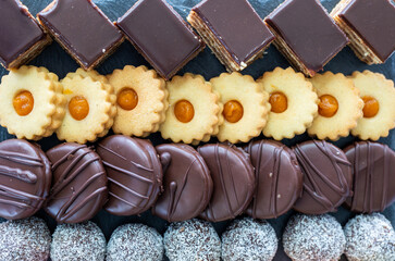 Macarons, chocolate cake and coconut balls in order on plate