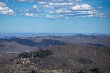 Endless Hills and Blue Sky Stretch Into the Horizon in Serene Wide Landscape
