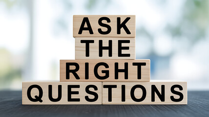 Ask the right questions text on wooden blocks stacked on a dark surface