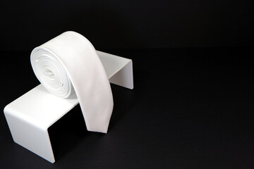plain white tie rolled on display stand close up shot single object concept nobody 
