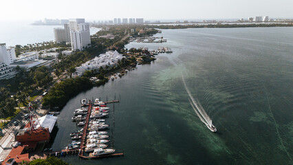 Boat sailing at a beautiful sunrise on the waters of the Cancun lagoon in the hotel zone.