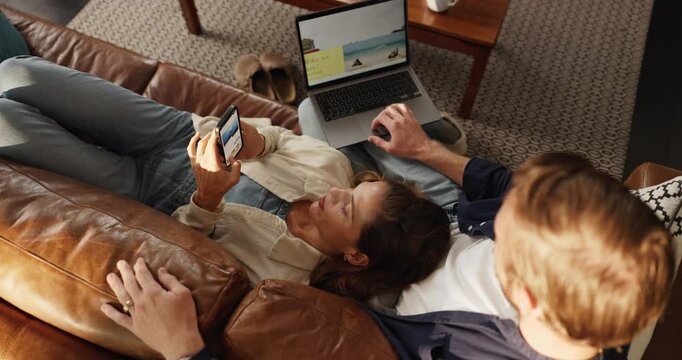 Above, laptop and couple on sofa, cellphone and online reading with website info. Home, subscription or man with woman, computer and smartphone with social media, chatting and weekend break in lounge