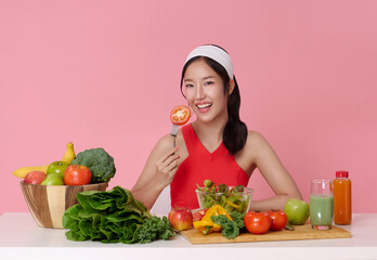 Beautiful Asian attractive sporty girl in sportswear enjoy eat clean vegetables after exercise for health on table kitchen. Diet and Healthy wellness food concept.