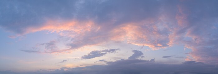 Panorama of a moody and wild cloudscape during blue hour after sunset