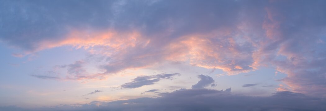 Panorama of a moody and wild cloudscape during blue hour after sunset