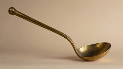 Vintage brass ladle with a long handle, showcasing intricate craftsmanship and a polished surface, ideal for culinary use or decorative display in kitchen settings