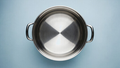 Stainless steel cooking pot with shiny surface and dual handles, placed on a light blue background, showcasing modern kitchenware and culinary design elements