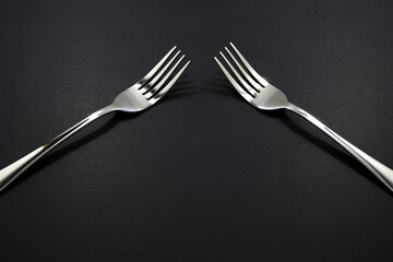 set of forks pairing together isolated on black background close-up view, Food concept photography