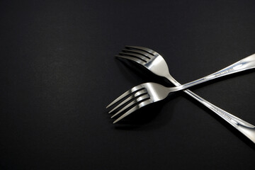 set of forks pairing together isolated on black background close-up view, Food concept photography