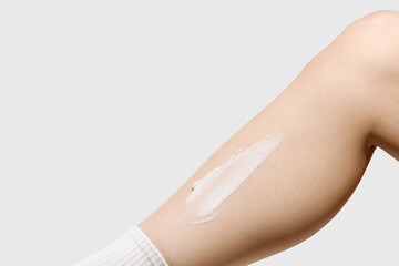 Close-up of a woman’s leg with a smear of moisturizing cream
