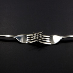 set of forks pairing together isolated on black background close-up view, Food concept photography