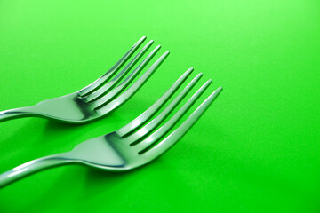 Fork's isolated on green background close up view, Food conceptual photography, Metal Forks together macro photography 