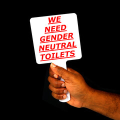 WE NEED GENDER NEUTRAL TOILET Sign board showing by hand with black background, Sign board holding hand close up view, Protester holding a sign board,  Conceptual photography 