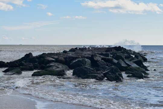 waves crashing on rocks - Powered by Adobe