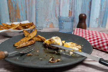 Person Eating Hamburger Steak with Egg and French Fries. Casual Dining Scene