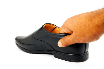 A formal black shoe holding hand on white background close-up view, A black shoe picking up by hand with white background close up shot 