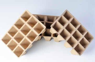 Three biodegradable seedling trays arranged diagonally on white background