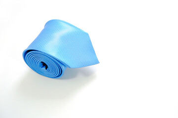 A blue tie rolled on white background closeup shot 