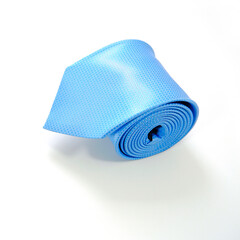 A blue tie rolled on white background closeup shot 